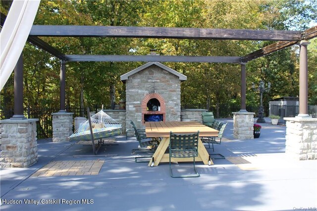 view of patio / terrace with a pergola and exterior fireplace