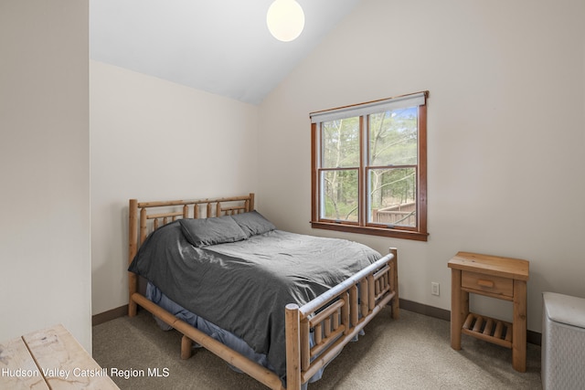bedroom featuring baseboards, vaulted ceiling, and carpet