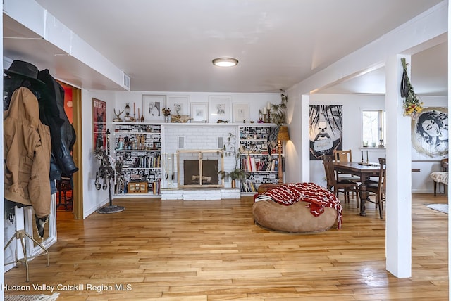 living room featuring a fireplace, wood finished floors, and visible vents