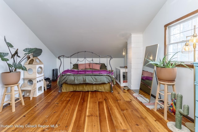 bedroom with hardwood / wood-style floors and vaulted ceiling