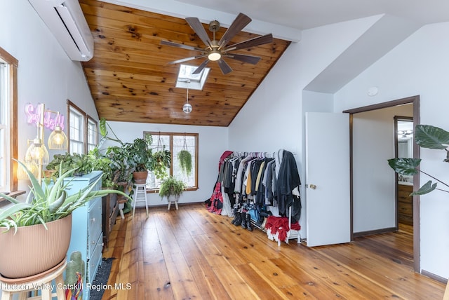 interior space with vaulted ceiling with skylight and an AC wall unit