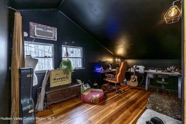 office area featuring wood-type flooring, a wall unit AC, and vaulted ceiling