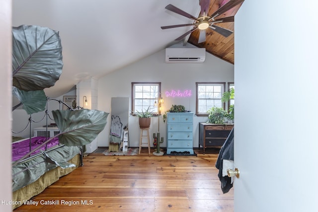 bedroom featuring lofted ceiling, an AC wall unit, and hardwood / wood-style floors