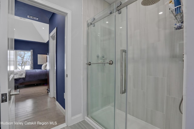 bathroom with hardwood / wood-style flooring and a shower with door