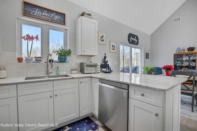 kitchen with backsplash, dishwasher, white cabinets, and sink