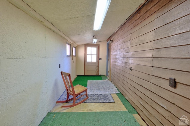 568 State Route 145, Middleburgh, NY 12122 - corridor with lofted ceiling, wood walls, a textured ceiling, and a textured wall