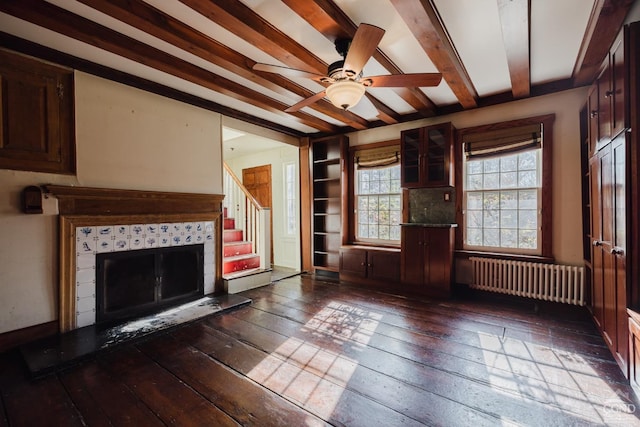 21 Cemetery Rd, New Lebanon, NY 12125 - unfurnished living room with radiator heating unit, dark wood-type flooring, beam ceiling, stairs, and a ceiling fan