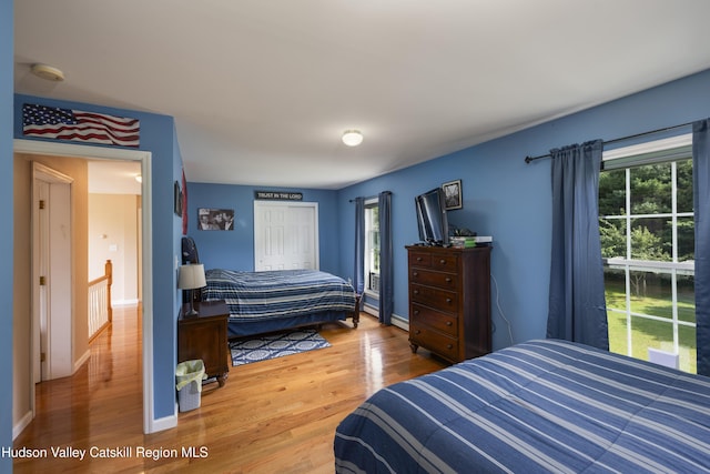 368 Gahbauer Rd, Hudson, NY 12534 - bedroom with wood finished floors, multiple windows, a closet, and a baseboard heating unit