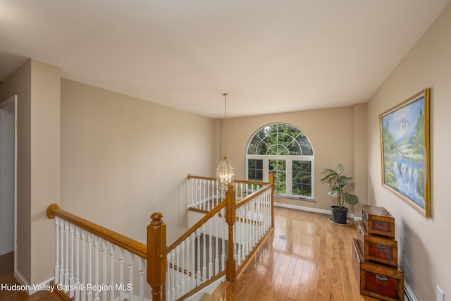 368 Gahbauer Rd, Hudson, NY 12534 - hallway with an upstairs landing, a chandelier, hardwood / wood-style floors, and a baseboard radiator
