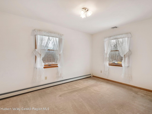 carpeted empty room with a baseboard heating unit