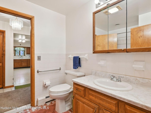 bathroom featuring tile patterned flooring, a chandelier, toilet, vanity, and tile walls