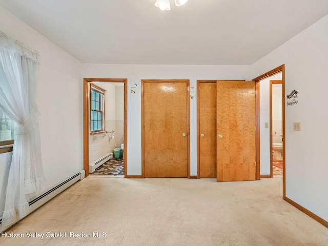 unfurnished bedroom with light colored carpet, baseboard heating, and connected bathroom