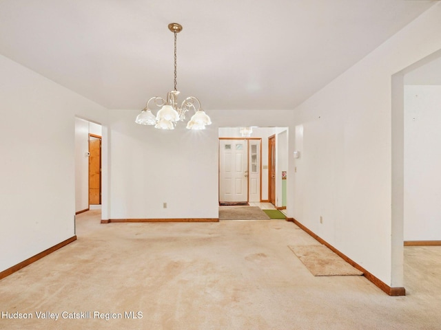 unfurnished dining area with light colored carpet and a notable chandelier