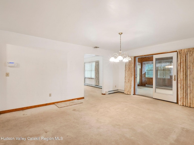 carpeted empty room featuring baseboard heating and a notable chandelier