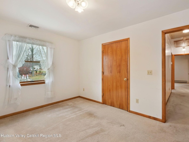 carpeted empty room featuring baseboard heating