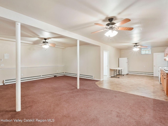 basement with carpet, white fridge, and a baseboard heating unit