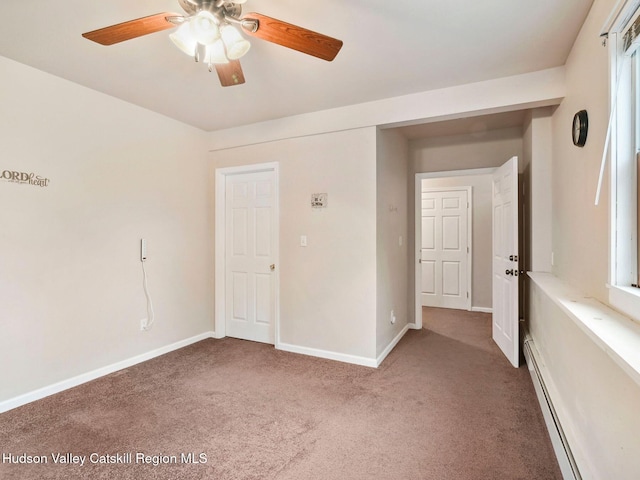 empty room with carpet flooring, ceiling fan, and a baseboard heating unit