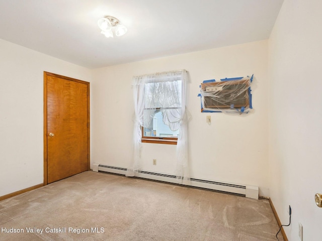 spare room with light colored carpet and baseboard heating