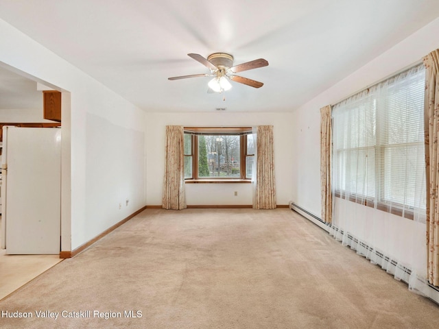 empty room featuring ceiling fan, light colored carpet, and baseboard heating