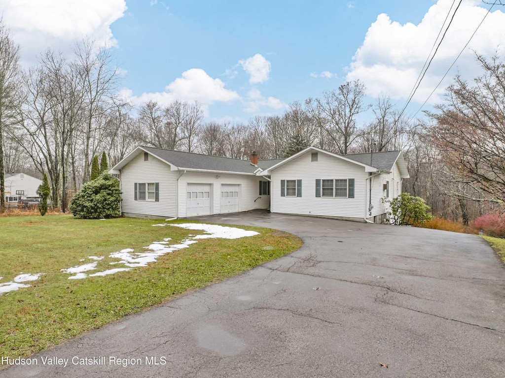 view of front of property with a garage and a front lawn