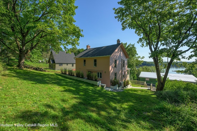 view of property exterior featuring a lawn and a water view