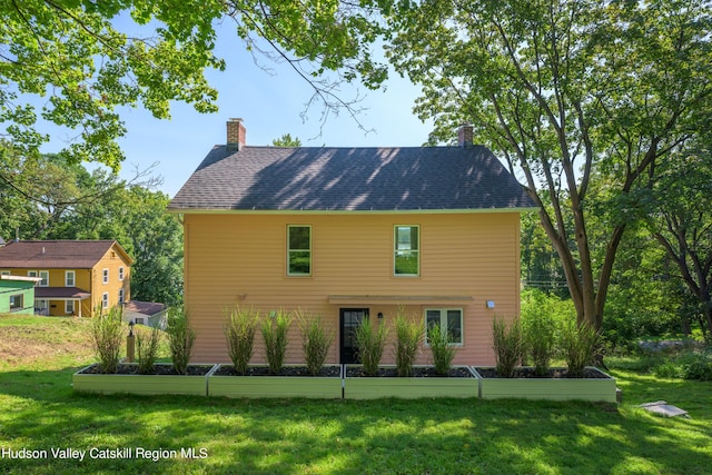 rear view of house with a yard