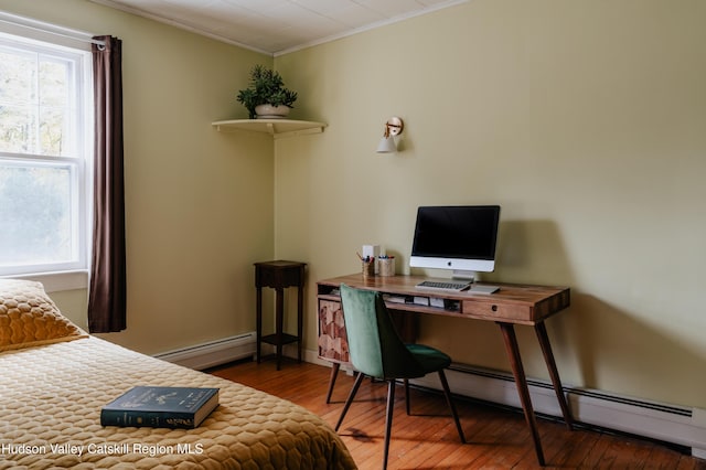 bedroom featuring hardwood / wood-style flooring, ornamental molding, baseboard heating, and multiple windows