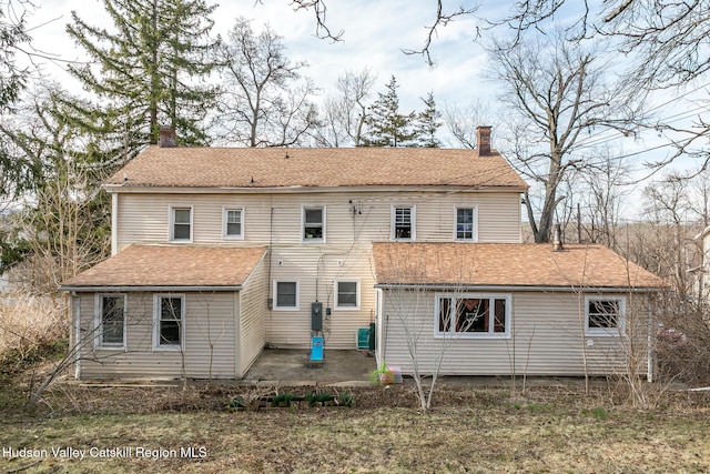 rear view of house with a chimney and a patio area