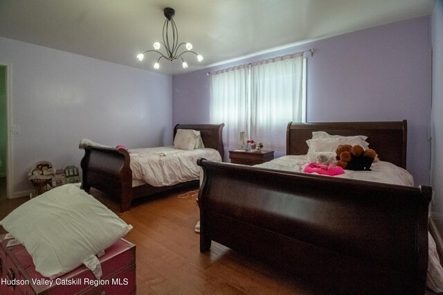 bedroom featuring a chandelier and wood-type flooring