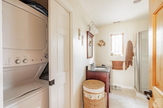 53 Snyder Pond Rd, Copake, NY 12516 - laundry area featuring stacked washer / dryer and light tile patterned floors