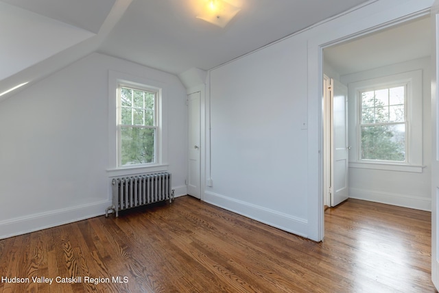 bonus room with radiator heating unit, dark wood-type flooring, and vaulted ceiling