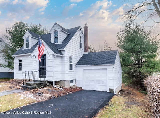 cape cod-style house featuring a garage