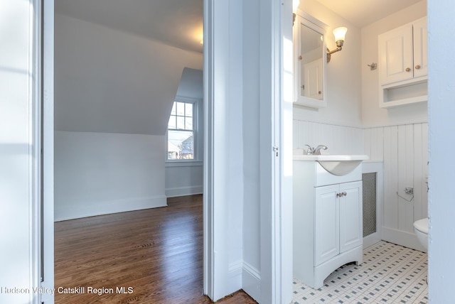 bathroom with toilet, hardwood / wood-style floors, vanity, and vaulted ceiling