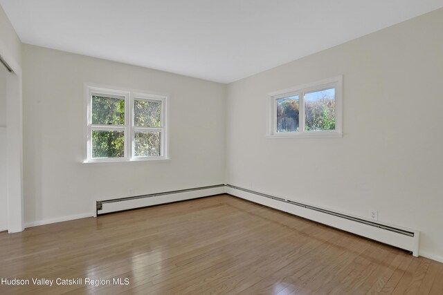 16-26 Shultis Brook Rd, Bearsville, NY 12409 - empty room with a baseboard heating unit, plenty of natural light, and light wood finished floors