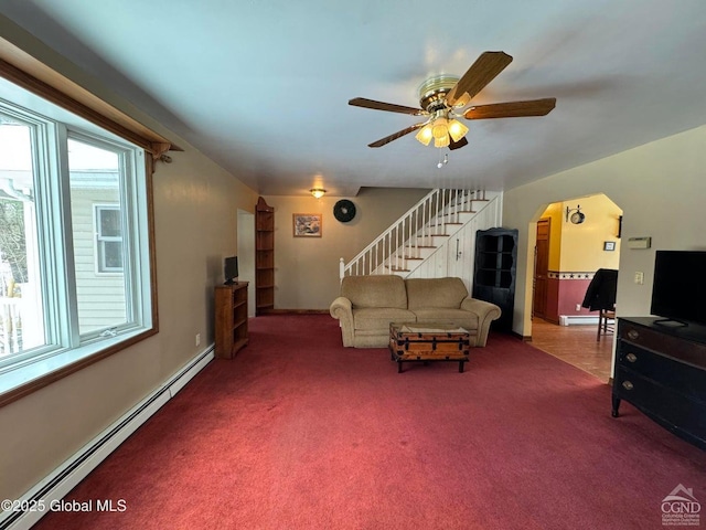 317 Scutt Rd, Greenville, NY 12083 - living room with a baseboard heating unit, stairway, ceiling fan, carpet flooring, and arched walkways