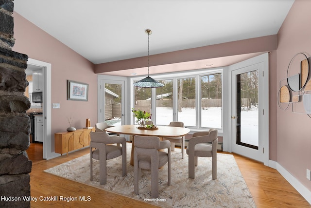 dining area featuring lofted ceiling and light hardwood / wood-style floors