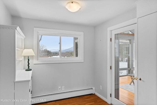 spare room featuring a mountain view, hardwood / wood-style floors, and baseboard heating