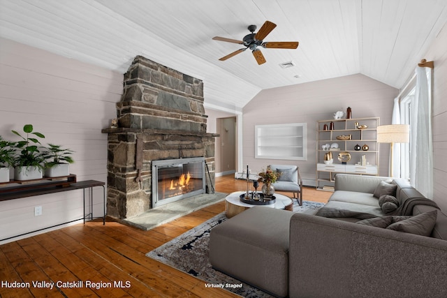 living room with ceiling fan, hardwood / wood-style floors, a fireplace, vaulted ceiling, and wood walls