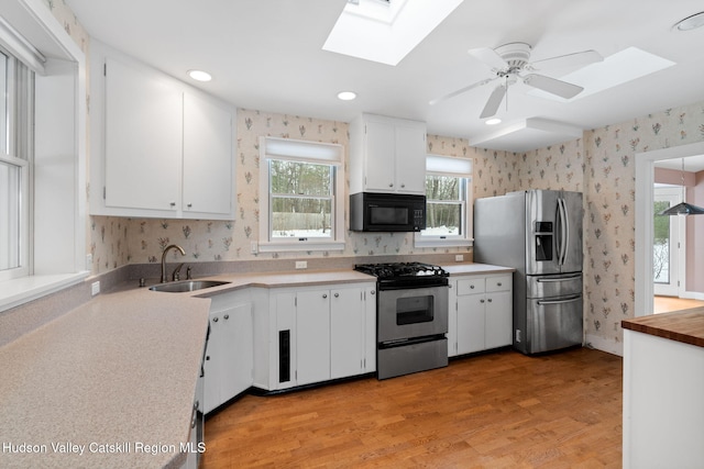 kitchen featuring appliances with stainless steel finishes, sink, and white cabinets