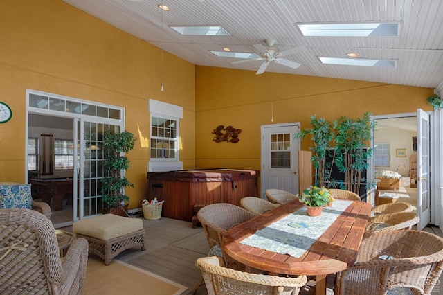  - dining space featuring a skylight, ceiling fan, and high vaulted ceiling