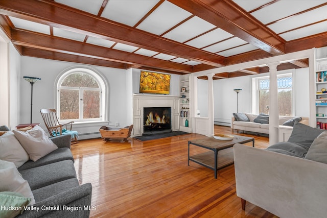 5868 Rte 209, Rochester, NY 12446 - living area featuring ornate columns, hardwood / wood-style floors, a warm lit fireplace, baseboard heating, and built in shelves