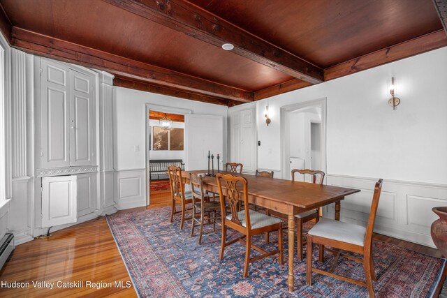 5868 Rte 209, Rochester, NY 12446 - dining room featuring light wood finished floors, beam ceiling, a decorative wall, a wainscoted wall, and a baseboard heating unit