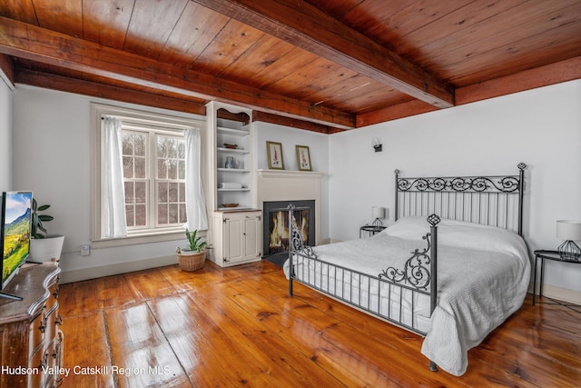 5868 Rte 209, Rochester, NY 12446 - bedroom featuring a wooden ceiling with exposed beams, hardwood / wood-style flooring, and a fireplace with flush hearth
