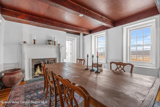 5868 Rte 209, Rochester, NY 12446 - dining room with wood finished floors, wainscoting, a wooden ceiling with exposed beams, a fireplace with flush hearth, and a decorative wall