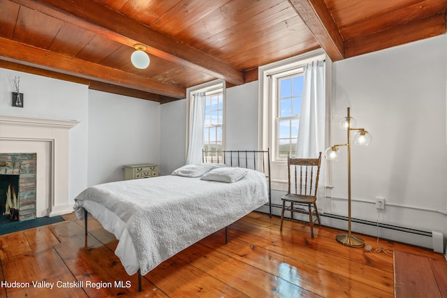 5868 Rte 209, Rochester, NY 12446 - bedroom with a baseboard heating unit, hardwood / wood-style floors, a wooden ceiling with exposed beams, and a fireplace with flush hearth