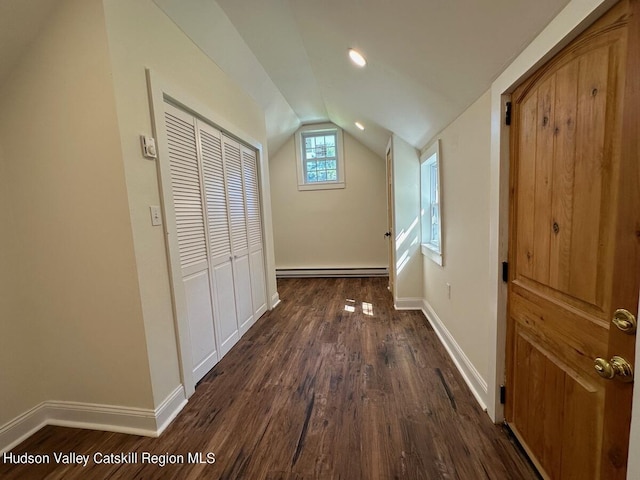 hallway featuring vaulted ceiling, dark hardwood / wood-style flooring, and a baseboard heating unit