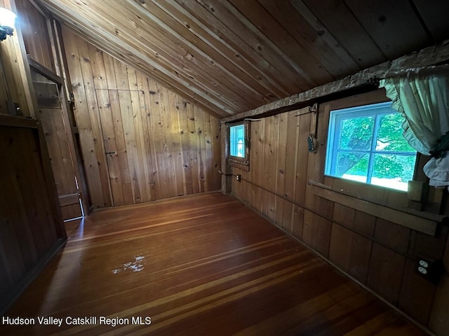 bonus room featuring hardwood / wood-style flooring, vaulted ceiling, and wood walls