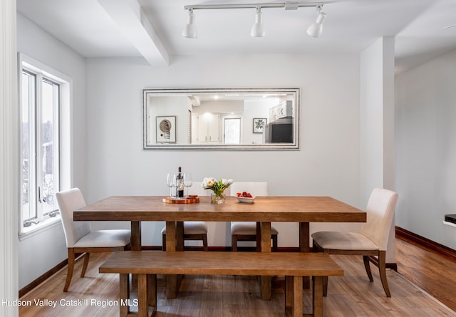 dining area with hardwood / wood-style floors and beamed ceiling