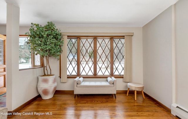 sitting room featuring hardwood / wood-style flooring, a baseboard radiator, and a wealth of natural light