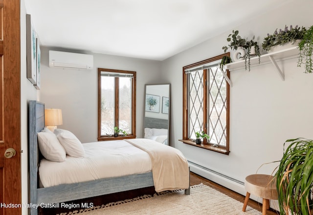 bedroom featuring a baseboard radiator, a wall mounted air conditioner, and hardwood / wood-style floors